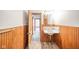 Bathroom with pedestal sink, wood-paneled walls, and access to other rooms at 503 S Harrison St, Alexandria, IN 46001