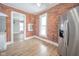 Kitchen features exposed brick, stainless steel refrigerator, and hardwood flooring at 503 S Harrison St, Alexandria, IN 46001