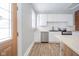 Renovated kitchen boasts white cabinets, stainless steel appliances, and exposed brick at 503 S Harrison St, Alexandria, IN 46001