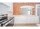 Modern kitchen with white cabinets, a light wood countertop, and exposed brick at 503 S Harrison St, Alexandria, IN 46001