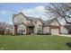 Two-story house with brick and siding, attached garage, and grassy yard at 6023 Twyckenham Dr, Indianapolis, IN 46236