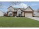 Two-story house with brick and siding, attached garage, and well-manicured lawn at 6023 Twyckenham Dr, Indianapolis, IN 46236