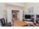 Home office with built-in shelves, desk, and view of dining room at 6023 Twyckenham Dr, Indianapolis, IN 46236