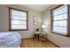 Bedroom with two windows, sitting area, and hardwood floors at 7385 E Troy Ave, Indianapolis, IN 46239