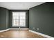 Spacious bedroom with dark green walls and herringbone floors at 1003 Alabama St, Indianapolis, IN 46202