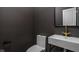 Dark-painted powder room with floating vanity, gold faucet, and a modern toilet at 1003 Alabama St, Indianapolis, IN 46202