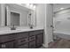 Modern bathroom features double sink vanity with dark cabinets and wood-look flooring at 1069 Ridgevine Rd, Greenwood, IN 46143