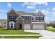 Beautiful two-story brick home with a three-car garage and manicured lawn at 1069 Ridgevine Rd, Greenwood, IN 46143