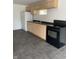 Basement kitchenette with black stove and light wood cabinets at 2722 Collier St, Indianapolis, IN 46241