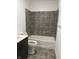 Updated bathroom with grey tile flooring and shower surround at 2722 Collier St, Indianapolis, IN 46241