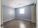 Spacious bedroom with grey walls, wood-look flooring, and a window at 2817 S Rybolt Ave, Indianapolis, IN 46241