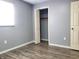 Bright bedroom with grey walls, wood-look flooring, and spacious closet at 2817 S Rybolt Ave, Indianapolis, IN 46241
