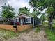 Traditional house with a cozy porch, a wooden fence, and a gravel driveway surrounded by trees at 2817 S Rybolt Ave, Indianapolis, IN 46241