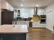 This kitchen features white cabinetry, stainless steel appliances, and a stylish island with a light countertop at 3156 Graceland Ave, Indianapolis, IN 46208