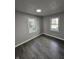 Bright bedroom with gray walls, vinyl wood flooring, and two large windows at 3262 Orchard Ave, Indianapolis, IN 46218