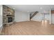 Open-concept living room featuring a stone fireplace, wood flooring, and staircase at 4068 Berry Chase Blvd, Greenwood, IN 46143
