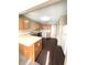 Galley kitchen with wood cabinets and white appliances at 621 Meadows Edge Ln, Indianapolis, IN 46217