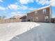 Spacious backyard with snow cover, and a brown two-story house at 6232 Emerald Springs Dr, Indianapolis, IN 46221