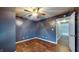 Bedroom featuring hardwood floors, ceiling fan, and a calming blue wall color at 7709 Santolina Dr, Indianapolis, IN 46237