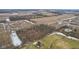 An aerial view shows the home is surrounded by farmland and trees for privacy at 9263 Compton Farm Ln, Indianapolis, IN 46259