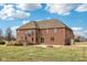 Exterior backyard showcasing a brick house, patio, manicured lawn and fire pit at 9263 Compton Farm Ln, Indianapolis, IN 46259
