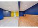Finished basement area featuring blue and yellow walls with carpet and wood-look flooring at 9263 Compton Farm Ln, Indianapolis, IN 46259