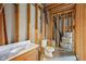 Close-up of an unfinished basement bathroom with a toilet, sink, and exposed framing at 9263 Compton Farm Ln, Indianapolis, IN 46259