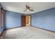 Blue bedroom with carpet, a ceiling fan, and an open doorway leading to other parts of the house at 9263 Compton Farm Ln, Indianapolis, IN 46259