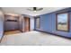 Bright bedroom with blue walls, carpet floors, wood trim, and windows offering natural light and outdoor views at 9263 Compton Farm Ln, Indianapolis, IN 46259