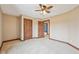Neutral bedroom with plush carpeting, a ceiling fan, and wooden doors, leading to other areas of the home at 9263 Compton Farm Ln, Indianapolis, IN 46259