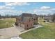 Brick home exterior showcases an attached three-car garage and a large, well-manicured lot at 9263 Compton Farm Ln, Indianapolis, IN 46259