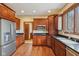 A functional kitchen includes stainless steel refrigerator, dark cabinets, and hardwood flooring at 9263 Compton Farm Ln, Indianapolis, IN 46259