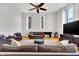 Living room with hardwood floors, a ceiling fan, and a large TV at 141 S Meridian St # 605, Indianapolis, IN 46225