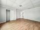 A simple bedroom with light gray walls, hardwood floors, and multiple doors at 1819 Southeastern Ave, Indianapolis, IN 46201