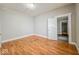 Bedroom with neutral walls and wood-look flooring, and access to another room at 1819 Southeastern Ave, Indianapolis, IN 46201