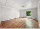 A simple bedroom with light gray walls and original-looking hardwood floors at 1819 Southeastern Ave, Indianapolis, IN 46201