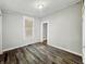 Bedroom with light gray walls, dark floors, a window, and access to other rooms at 1819 Southeastern Ave, Indianapolis, IN 46201