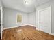 Well-lit bedroom with hardwood floors, a window, and neutral wall colors at 1819 Southeastern Ave, Indianapolis, IN 46201