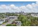 An aerial view featuring a city skyline in the distance, located behind the residential community and its trees at 1819 Southeastern Ave, Indianapolis, IN 46201