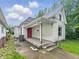 Exterior view of the house showcasing a red front door and a trash can near the porch at 1819 Southeastern Ave, Indianapolis, IN 46201