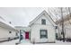 Charming white house with red door, covered porch, and snowy yard at 1819 Southeastern Ave, Indianapolis, IN 46201