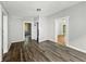 Living room with light gray walls and dark floors with multiple doorways at 1819 Southeastern Ave, Indianapolis, IN 46201