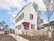 Charming two-story home with white siding, contrasting trim, pink door, and a cute picket fence at 220 N Beville Ave, Indianapolis, IN 46201