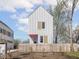 Charming two-story home with white siding, contrasting trim, pink door, and a cute picket fence at 220 N Beville Ave, Indianapolis, IN 46201