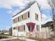 Charming two-story home with white siding, contrasting trim, pink door, and a cute picket fence at 220 N Beville Ave, Indianapolis, IN 46201