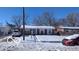 Ranch-style home with a snow-covered lawn and driveway at 2714 Baltimore Ave, Indianapolis, IN 46218