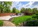 Backyard with a hot tub, stone patio, manicured lawn, and lush landscaping at 4601 N Legacy Dr, Muncie, IN 47304