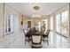 Bright dining room with marble floors, large windows, and an elegant chandelier above the large dining table at 4601 N Legacy Dr, Muncie, IN 47304