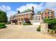 Expansive driveway leading to a grand red brick home with meticulously maintained landscaping and attached garages at 4601 N Legacy Dr, Muncie, IN 47304