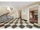 Elegant foyer with black-and-white checkered flooring, a curved staircase, and decorative wall panels at 4601 N Legacy Dr, Muncie, IN 47304
